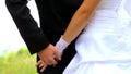 Young couple holding hands standing together in park