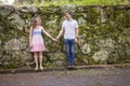 Young couple holding hands by stone wall Royalty Free Stock Photo