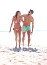 Young couple holding hands and walking on beach. Royalty Free Stock Photo