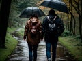 Young couple with holding hands walking through a park in a rainy day Royalty Free Stock Photo