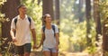 Young Couple Holding Hands Wearing Backpacks Hiking Along Trail Through Countryside Royalty Free Stock Photo