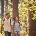 Young Couple Holding Hands Wearing Backpacks Hiking Along Trail Through Countryside Royalty Free Stock Photo