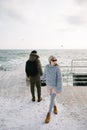 young couple holding hands on winter quay