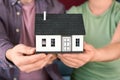 Young couple holding house model, closeup. Mortgage concept Royalty Free Stock Photo