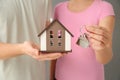 Young couple holding house model and key, closeup. Mortgage concept Royalty Free Stock Photo