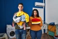 Young couple holding laundry dirty and clean laundry depressed and worry for distress, crying angry and afraid Royalty Free Stock Photo