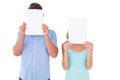 Young couple holding pages over their faces Royalty Free Stock Photo