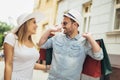 Young couple holding shopping bags on their shoulders while walking down the street after shopping Royalty Free Stock Photo