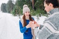 Young couple holding snow heart in winter forest. Hands in knitted mittens with heart of snow in winter day. Love Royalty Free Stock Photo