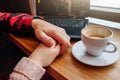 Young couple holds hands and enjoys coffee in the cafe while using a laptop Royalty Free Stock Photo