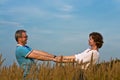 Young couple holds hands on a meadow