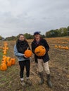 A young couple holds pumpkins at a pumpkin patch Royalty Free Stock Photo