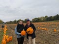 A young couple holds pumpkins at a pumpkin patch Royalty Free Stock Photo