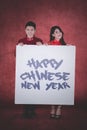 Young couple holds text of happy Chinese new year Royalty Free Stock Photo