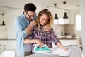 Young couple at home doing hosehold chores and ironing Royalty Free Stock Photo