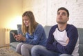 Young couple at home sofa couch with woman internet and mobile phone addiction ignoring her boyfriend feeling sad jealous frustrat Royalty Free Stock Photo