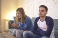 Young couple at home sofa couch with woman internet and mobile phone addiction ignoring her boyfriend feeling sad jealous frustrat Royalty Free Stock Photo