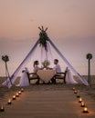 Young couple Honeymoon dinner by candle light during sunset on the beach, men and woman having dinner on the beach Royalty Free Stock Photo