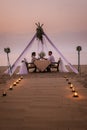 Young Couple Honeymoon Dinner By Candle Light During Sunset On The Beach, Men And Woman Having Dinner On The Beach