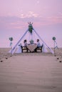 Young Couple Honeymoon Dinner By Candle Light During Sunset On The Beach, Men And Woman Having Dinner On The Beach