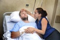 Young couple at hospital room man lying in bed worried woman holding his hand caring Royalty Free Stock Photo