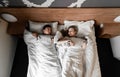 Beautiful happy young couple or family waking up together in bed