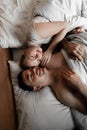 Beautiful happy young couple or family waking up together in bed Royalty Free Stock Photo