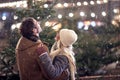 A young couple in hug watching snowflakes in the city. Christmas tree, love, relationship, Xmas, snow Royalty Free Stock Photo