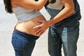 Young couple hugging her belly with hands excitedly waiting for her first child