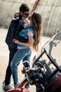 Young couple hugging and kissing while standing near motorbike Royalty Free Stock Photo