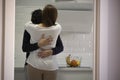 Young couple hugging in the kitchen of their house. concept of psychological help