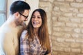 Young couple hugging next to the window, brick wall background Royalty Free Stock Photo