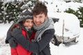 Young couple hugging in snow with car Royalty Free Stock Photo