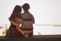 Young couple hugging in the summer daylight on a bridge construction in the city outdoors. copy space