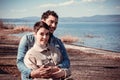 Beautiful couple sitting on the shore of Lake Bracciano. Royalty Free Stock Photo