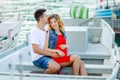 Young couple hugs and relaxing at dock near boat, on sunny summer day. Woman and man in fashionable clothes stands near Royalty Free Stock Photo