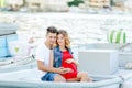 Young couple hugs and relaxing at dock near boat, on sunny summer day. Woman and man in fashionable clothes stands near Royalty Free Stock Photo