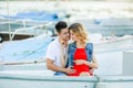 Young couple hugs and relaxing at dock near boat, on sunny summer day. Woman and man in fashionable clothes stands near Royalty Free Stock Photo