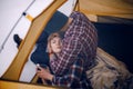 Young couple hugs in tent during winter hike. Guy sits, girl lies on guy`s knees. Royalty Free Stock Photo