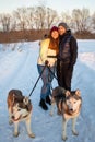 Young Couple With A Husky Dog Walking In Winter Park At Sunset Royalty Free Stock Photo