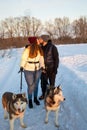 Young Couple With A Husky Dog Walking In Winter Park At Sunset Royalty Free Stock Photo