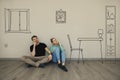 Couple imagine interior of new house. sitting on floor and thinking in empty room