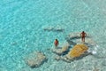 Young couple inside paradise clear torquoise blue water in Favignana island, Cala Azzura Beach, Sicily South Italy