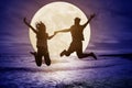 Couple jumping on beach and watching the moon.Celebrate Mid autumn festival