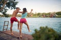 Young couple jumping from a pier into the water