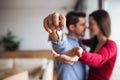 A young couple with a key and cardboard boxes moving in a new home. Royalty Free Stock Photo