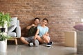 Young couple with key sitting on floor in their new house Royalty Free Stock Photo