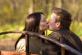 Young couple kiss on a bench in park Royalty Free Stock Photo