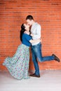 Young couple kiss in front of red brick wall. Royalty Free Stock Photo