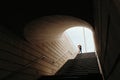 A young couple kisses in the light at the end of a large dark underpass similar to a tunnel Royalty Free Stock Photo